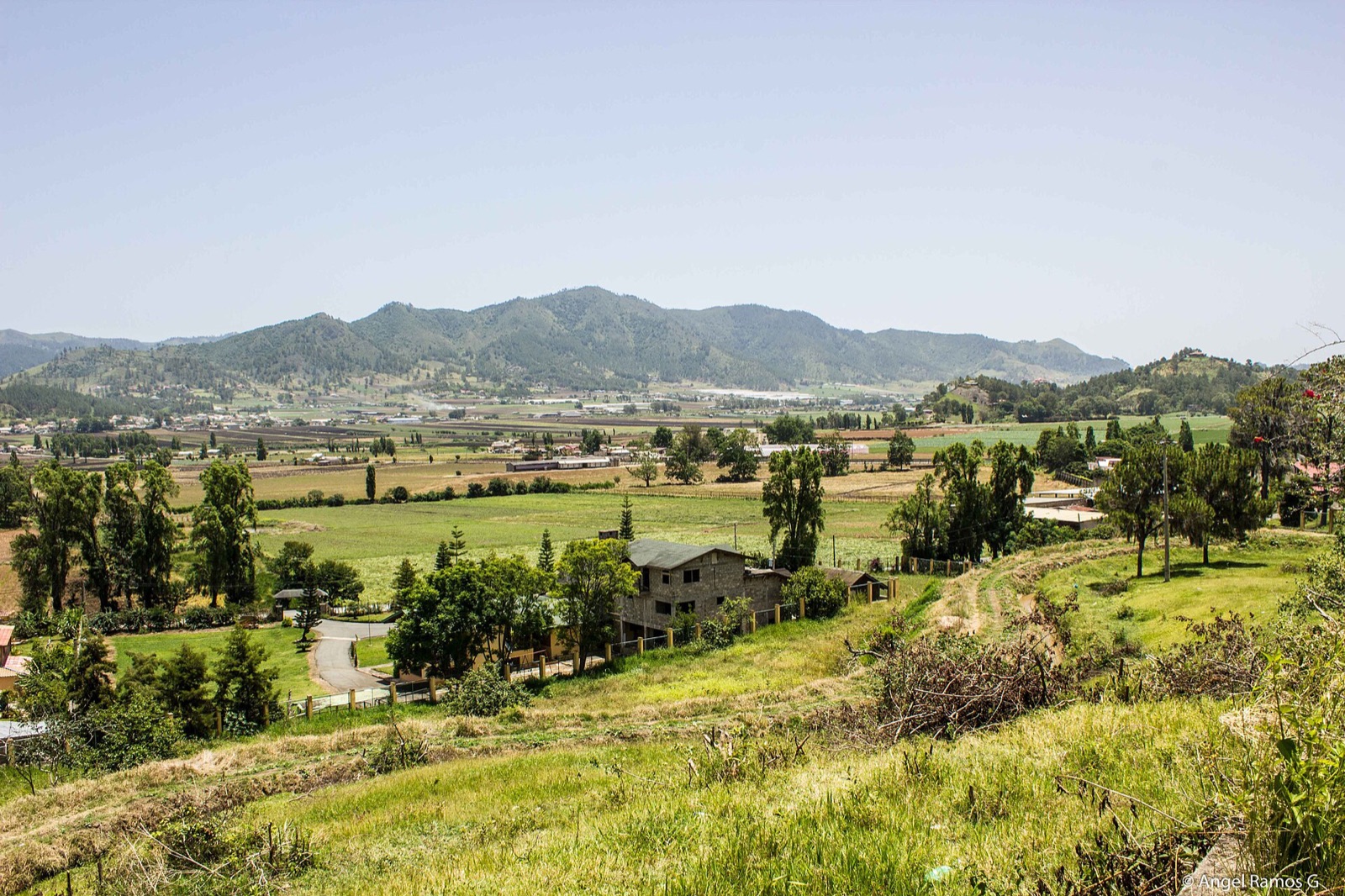 Green farmland and mountain ridges in the Constanza valley in the Dominican interior